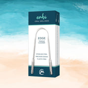 embi EDGE stainless steel tongue cleaner packaging on beach background for fresh breath and oral hygiene