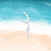 embi premium floss pick with a silk string on a beach theme background 